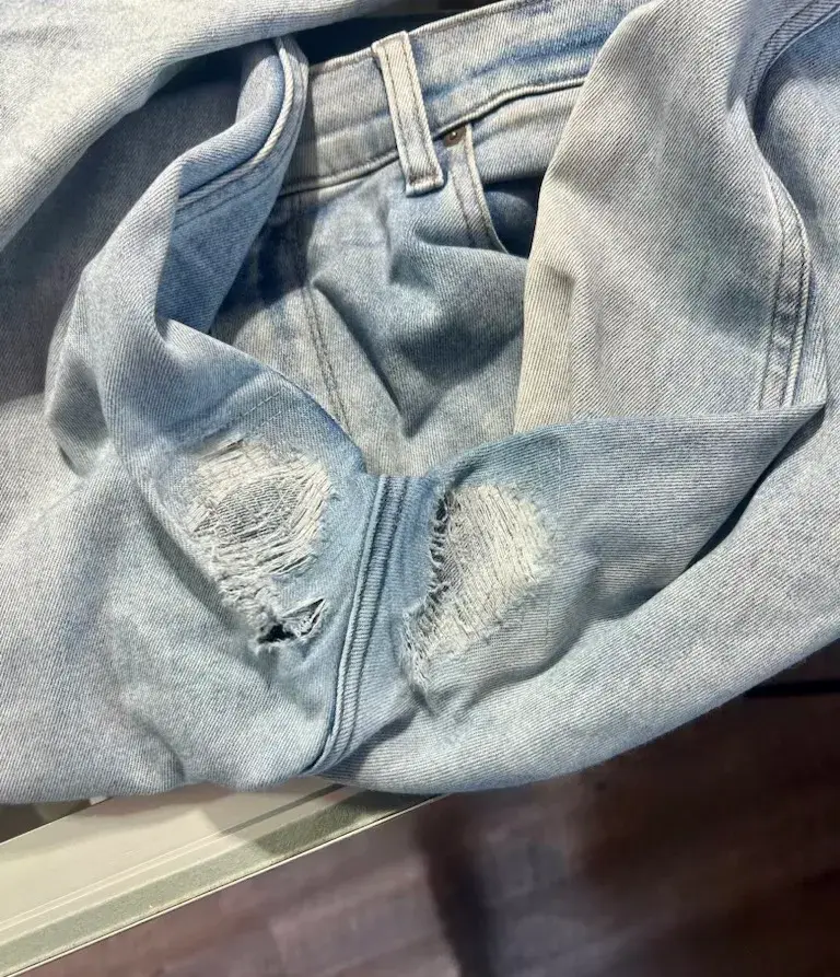 Worn-through inner thighs on light-wash jeans before denim reweave repair at Baroni Cleaners Irvine