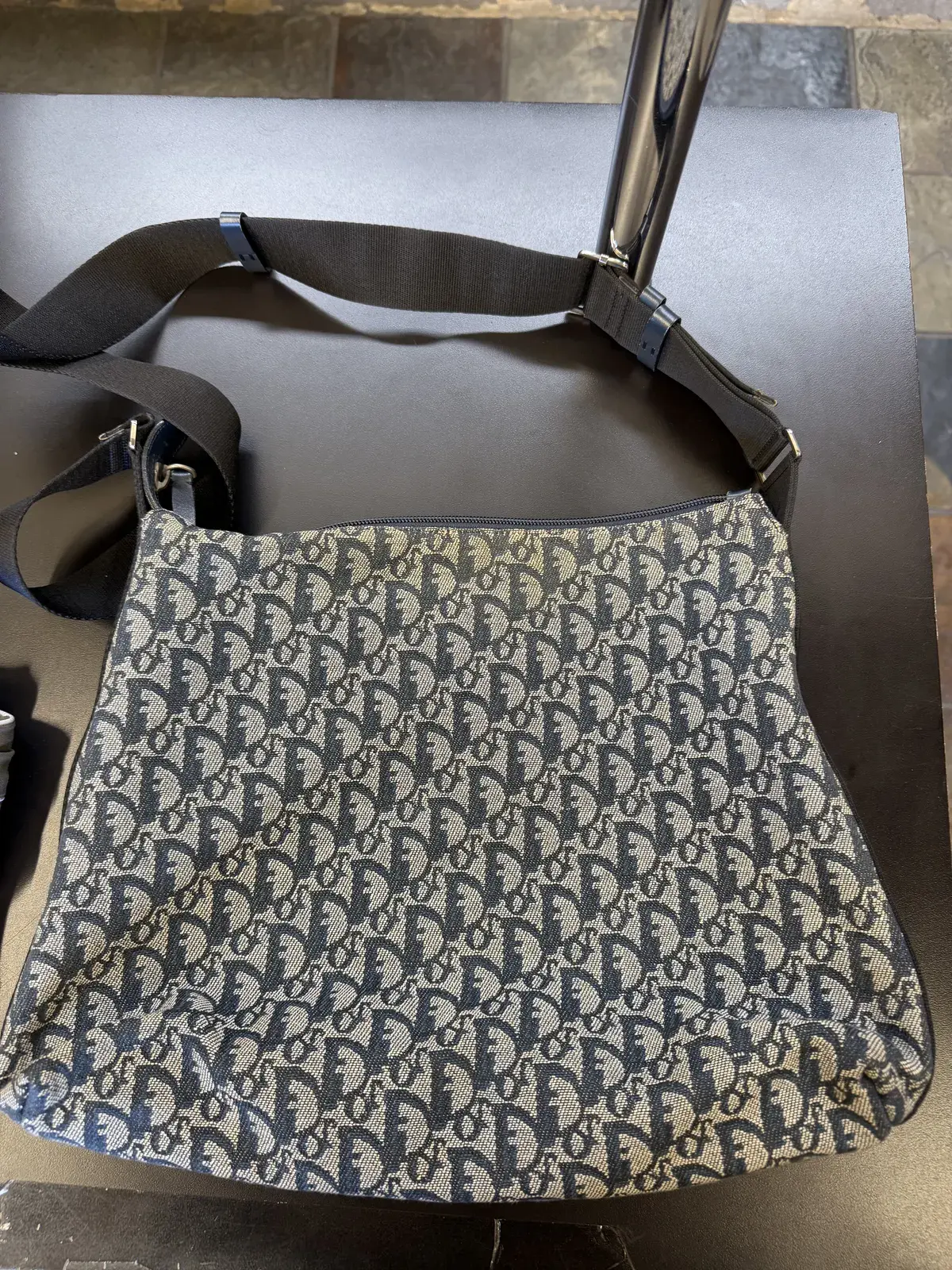 Back panel of the Dior Trotter canvas bag before cleaning, the ecru weave dulled and grey along the zipper and toward the lower corners