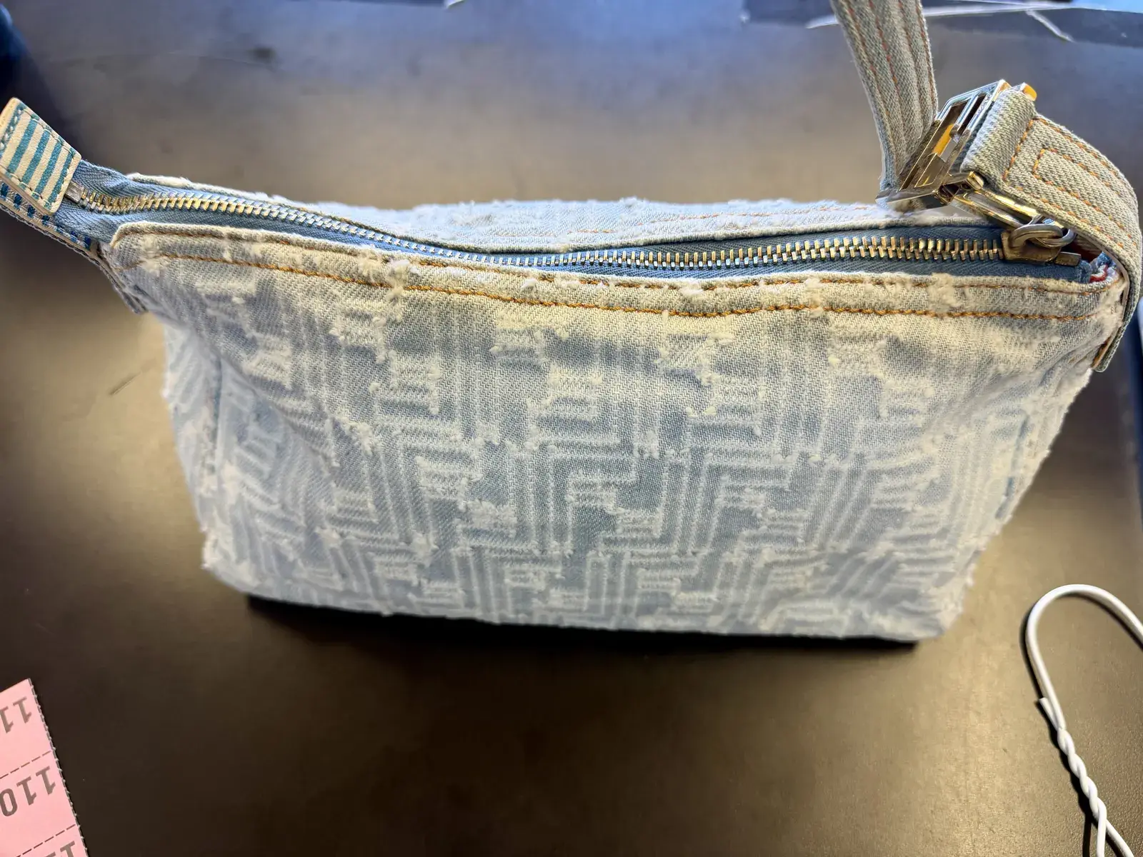 Cleaned Fendi Zucca denim bag from the side, the striped strap and denim body free of the yellow band that ran along the top