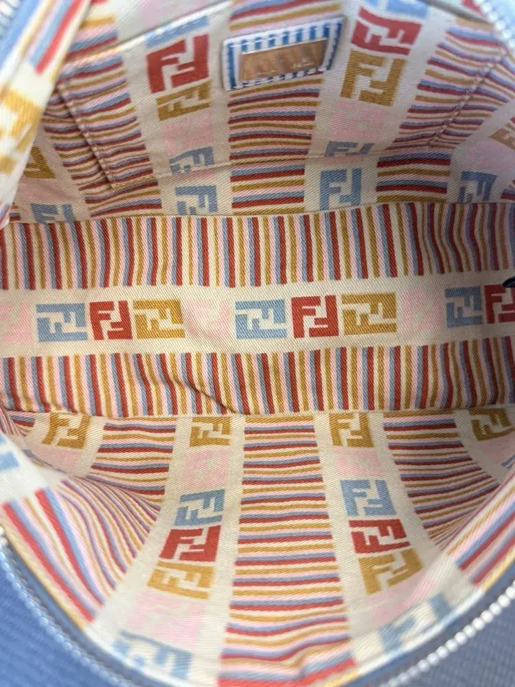 The same striped Fendi FF logo lining after cleaning, stripes and logos reading bright red, blue, gold, and cream again