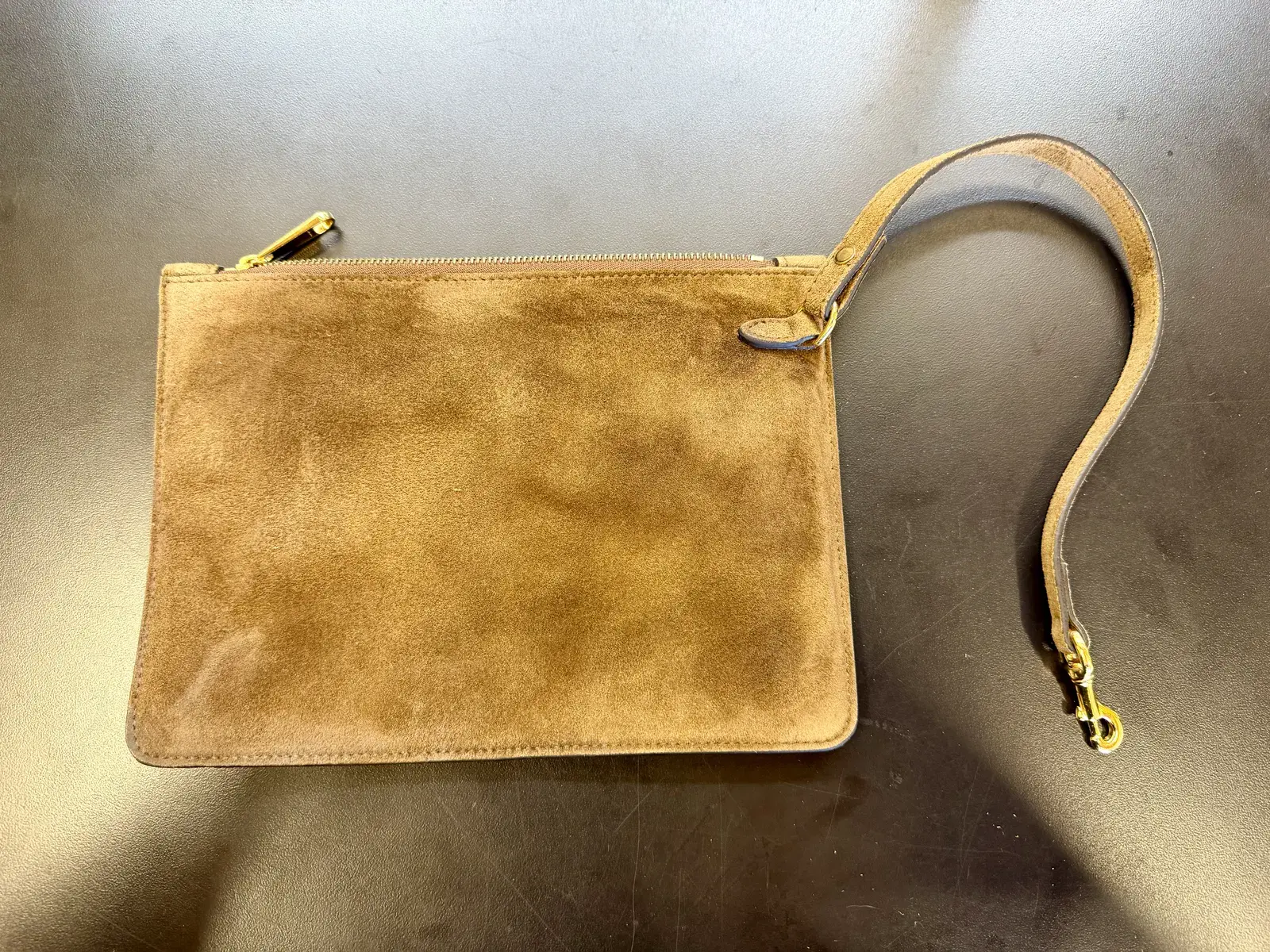 The Gucci detachable suede zip pouch with its wrist strap after cleaning, even brown suede with no dark oil patches