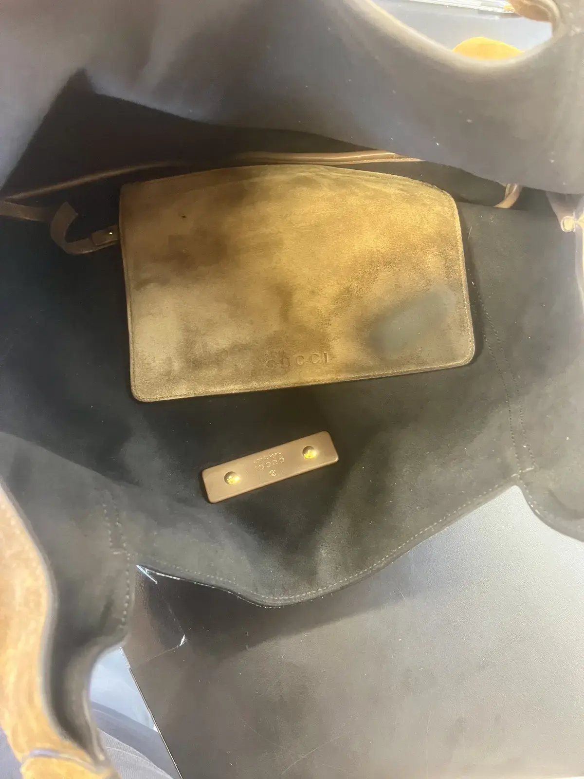 Inside the Gucci hobo before cleaning, the detachable Gucci suede pouch heavily oil stained against the black suede lining