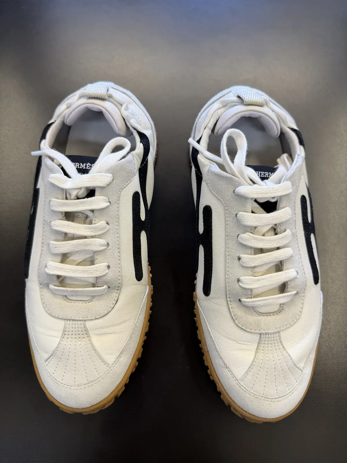 The same Hermes sneakers after cleaning at Baroni Cleaners Irvine, leather brightened back to white and suede refreshed