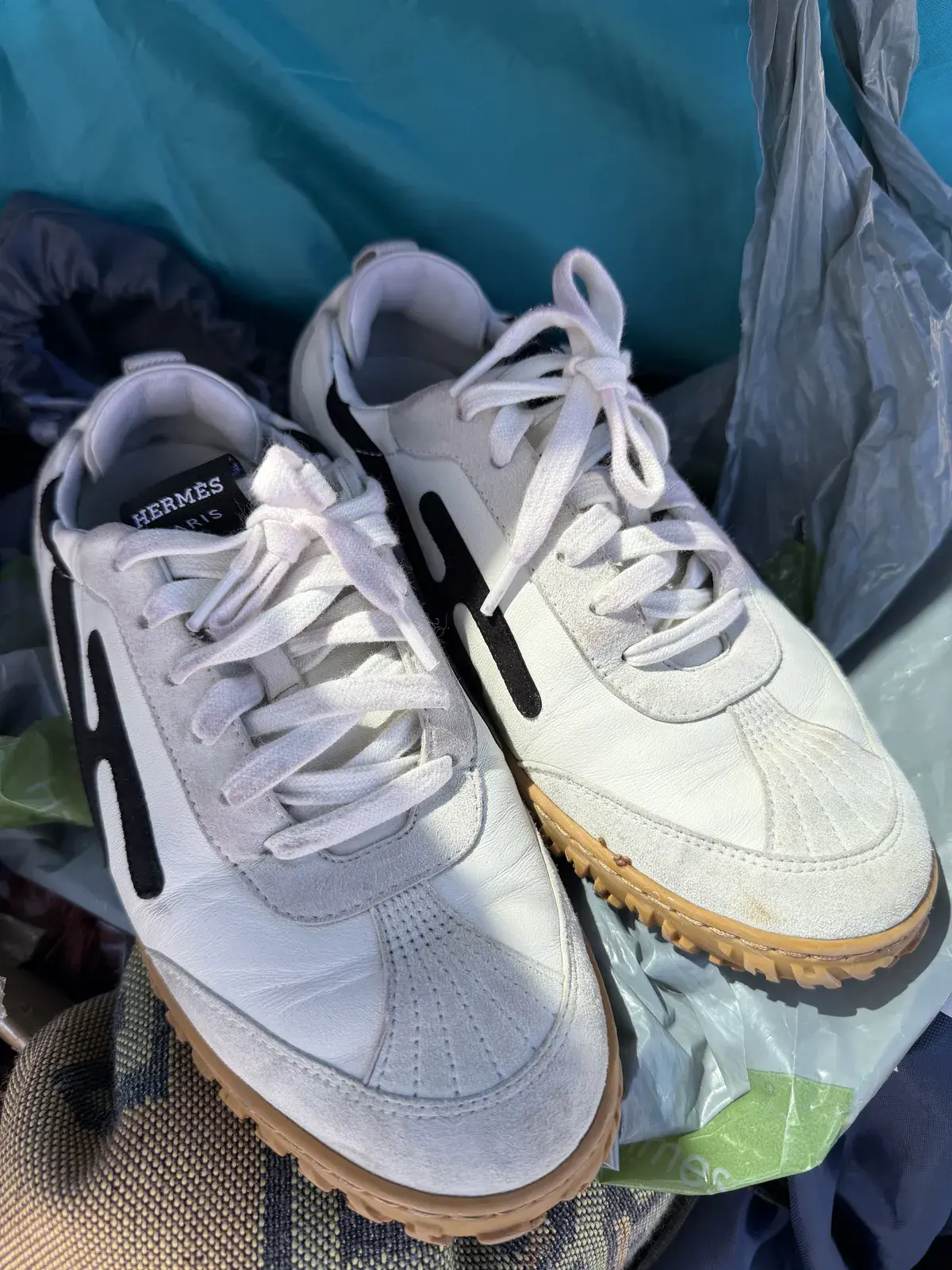 Pair of Hermes Paris white leather and suede sneakers before cleaning, greyed leather, soiled suede panels, and discolored soles