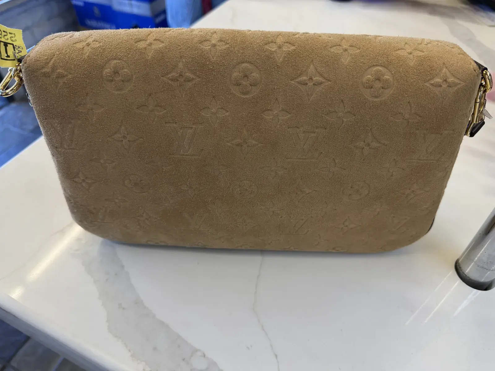 Back panel of the Louis Vuitton suede Pochette Métis Soft MM at intake, before dye transfer removal