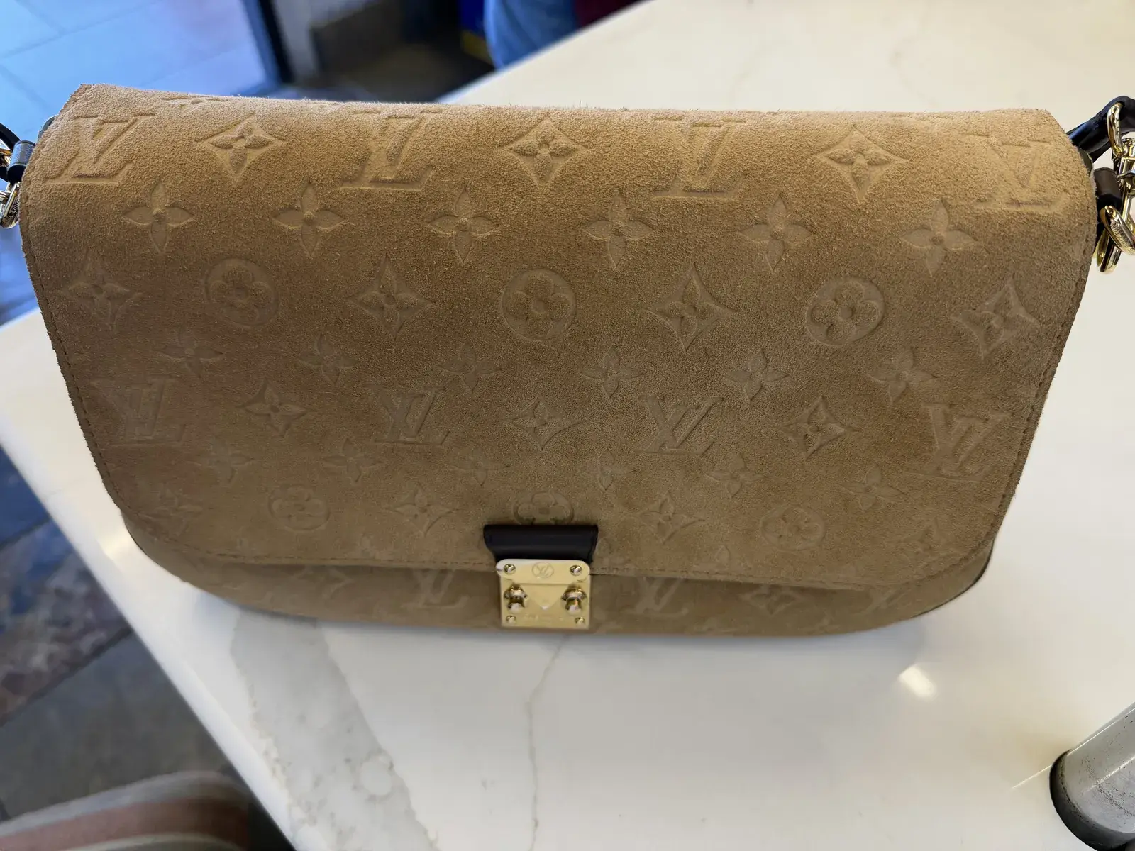 Louis Vuitton Pochette Métis Soft MM in Beige Trench Monogram Empreinte suede at intake at Baroni Cleaners, front flap and gold S-lock before cleaning