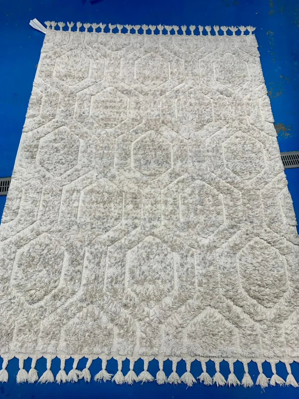 The same Moroccan style shag rug after a professional wash at Baroni Cleaners Irvine, pile lofted and bright cream again with clean braided tassels