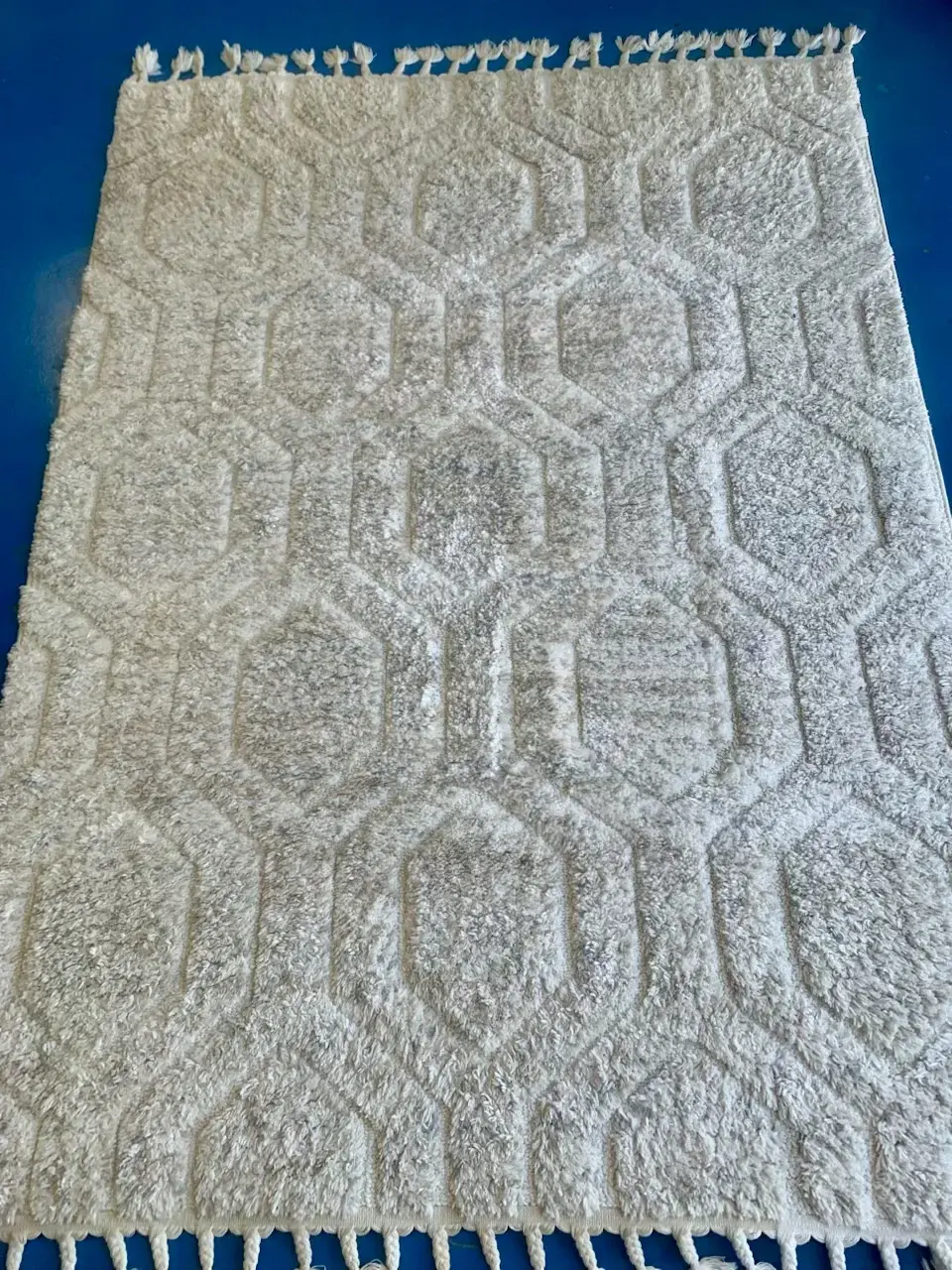 Cream Moroccan style shag area rug before cleaning, high pile matted flat and greyed by ground-in soil