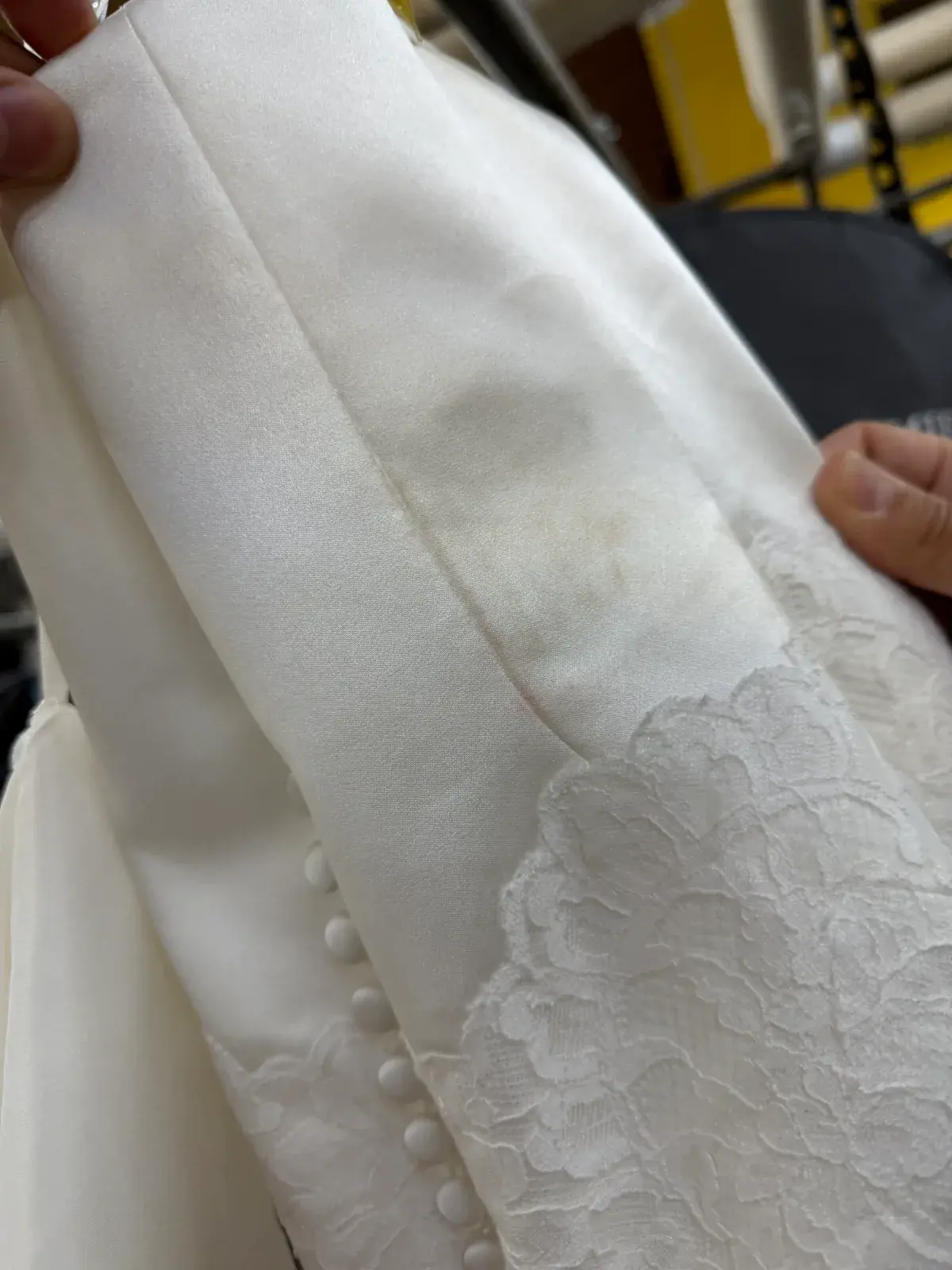 Staining on the satin next to the lace and covered buttons before cleaning at Baroni Cleaners Irvine